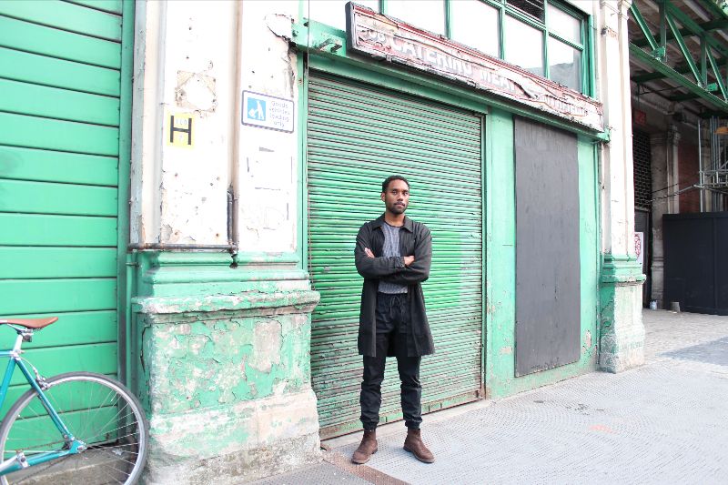 Photograph of Jordan Rowe outside Smithfield Market, with a bike in the corner of the shot