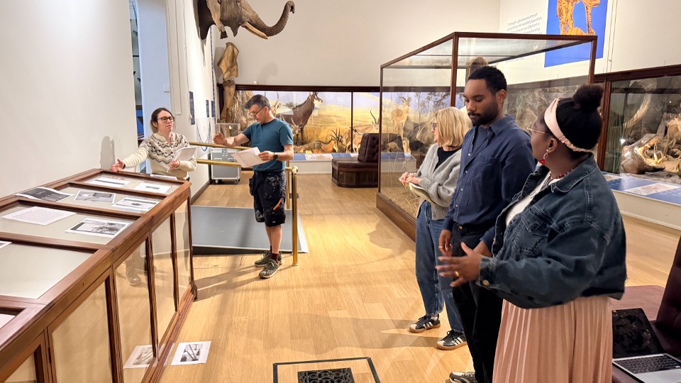 Four people standing around a display case in a gallery